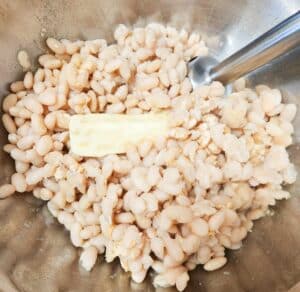 soaked white navy beans and grass fed butter in a bowl with an immersion blender