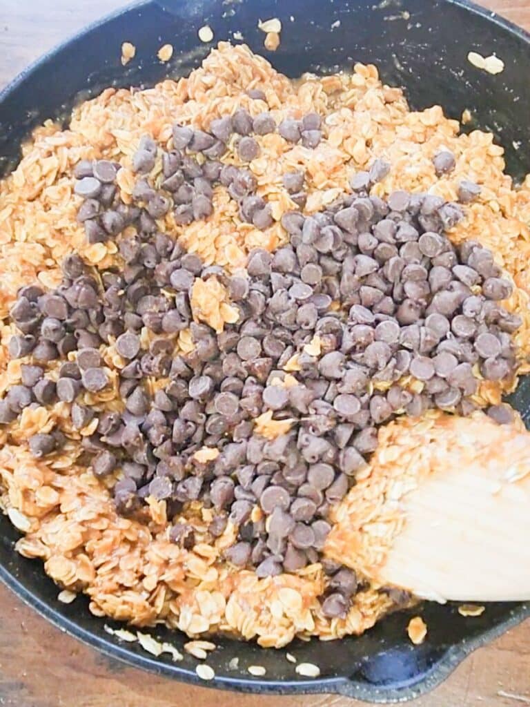 folding in oats and chocolate chips in gluten, dairy, and sugar free monster cookies