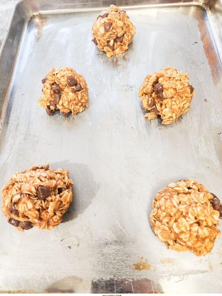 scoops of gluten, dairy, & sugar free monster cookie dough on greased pan