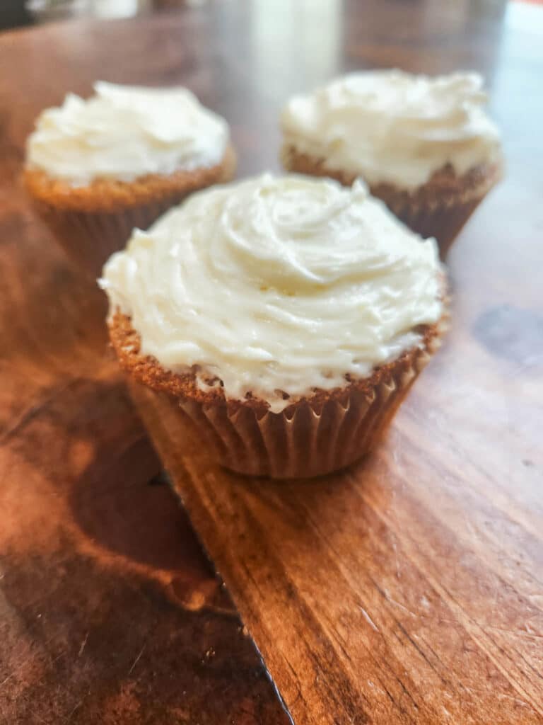 sourdough fresh milled flour cupcakes with cream cheese frosting presented on cutting board