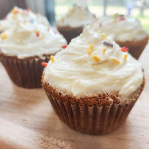 sourdough vanilla cupcakes with fresh milled flour presented on cutting board topped with whipped cream cheese frosting