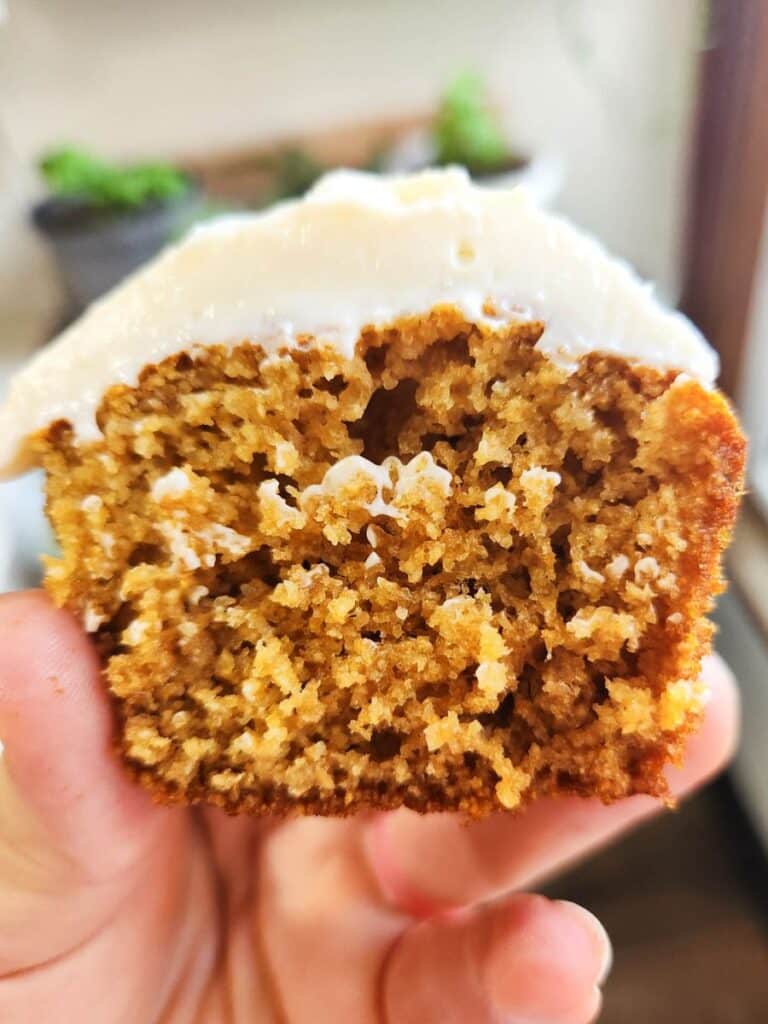 sourdough vanilla cupcake with fresh milled flour, cut in half, showing tender crumb and cream cheese whipped frosting